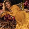 Woman in a yellow dress posing on patterned fabric 