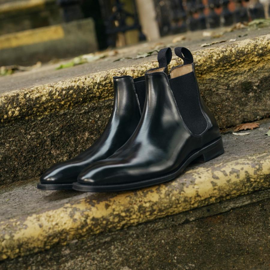 Shiny black Chelsea boots on a step