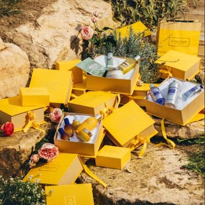 Yellow L'Occitane boxes piled high outdoors in the summer