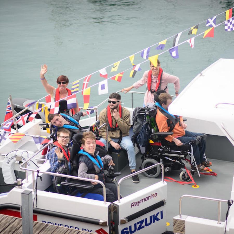Group of young people on a boat with colourful bunting