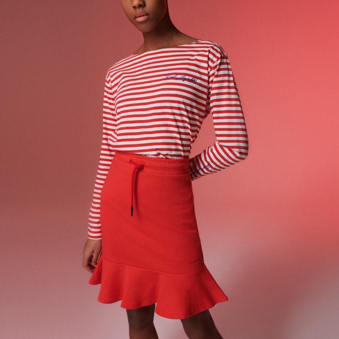 Model in rep stripe tee and red mini skirt