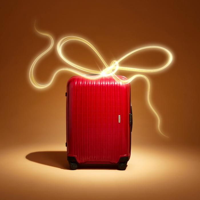 Red luxury suitcase with glowing gold bow