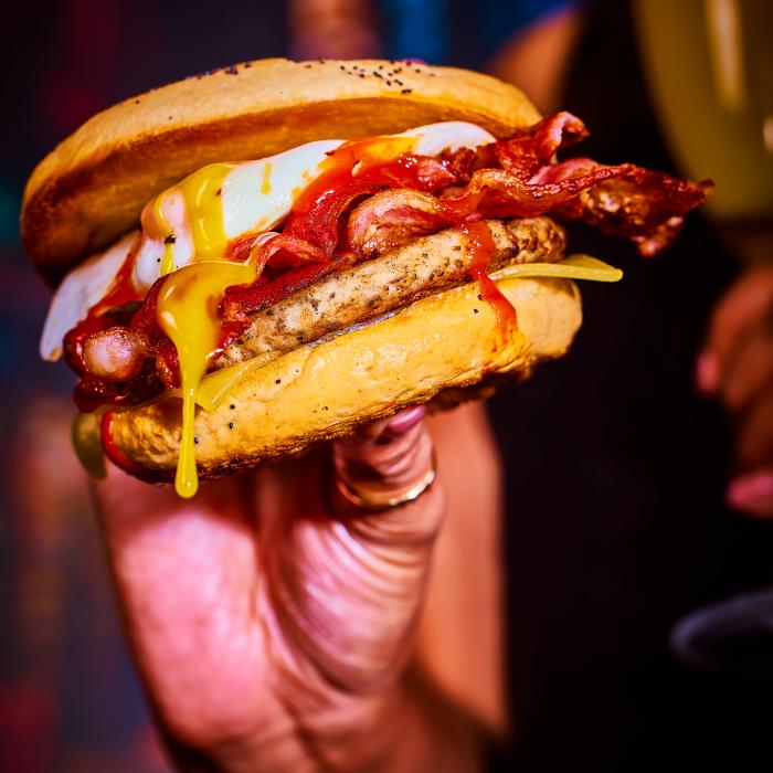 close up of a sausage and bacon bagel 